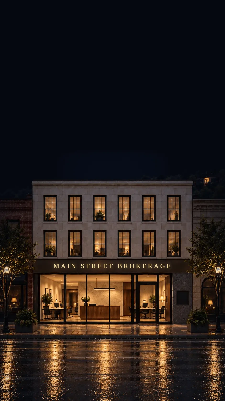 Main Street Brokerage on a quiet main street at night, its glass storefront lit