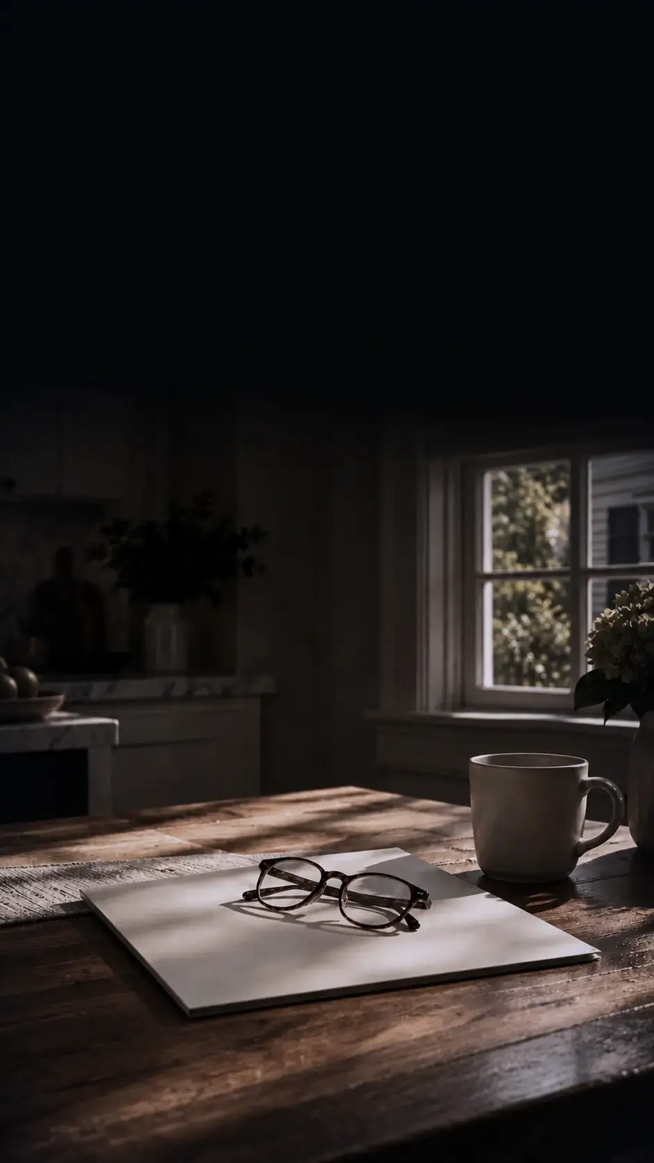 Seller Dana’s kitchen table in the morning light, reading glasses on a notepad beside a mug